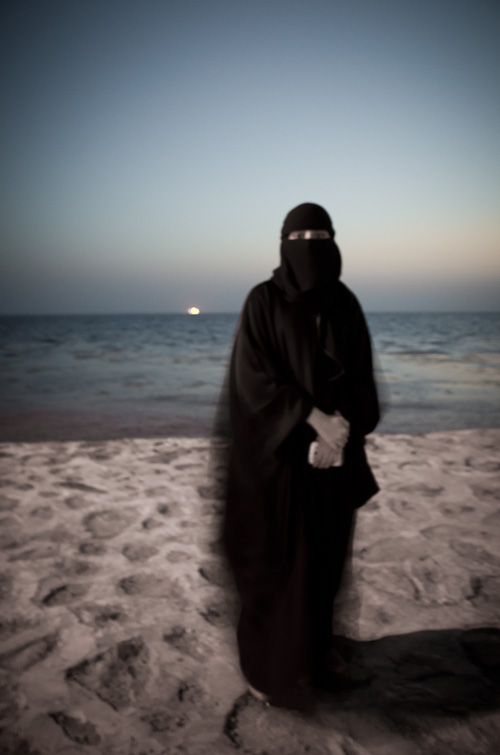 gesluierde studente op het strand in het Midden Oosten
