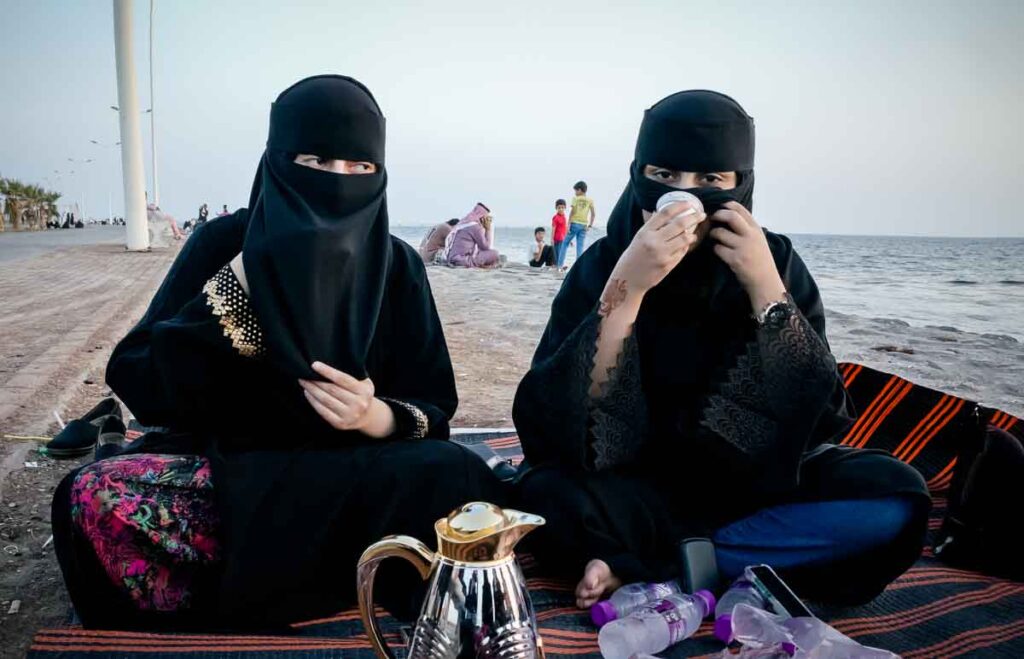 gesluierde studentes op het strand in het Midden Oosten